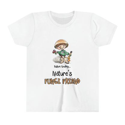 A white official Grolings kids' t-shirt, featuring the phrase 'Button Groling... Nature’s Fungi Friend.' The t-shirt showcases Button Groling, holding a little group of toadstools in one hand and a mushroom brush in the other. Beside Button Groling, there are two large puffball mushrooms, symbolising the importance of fungi in the forest ecosystem.