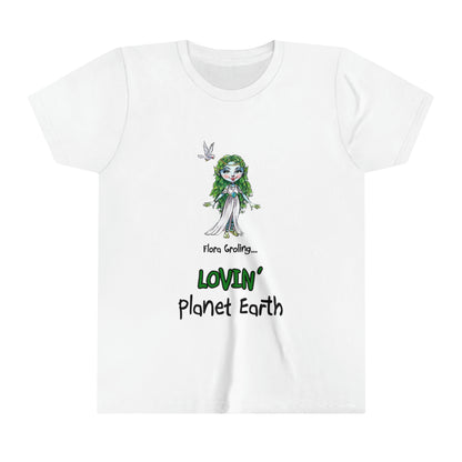 A white kids' t-shirt from the 'The Grolings Say...' collection, featuring the phrase 'Flora Groling says... I'm Lovin' Planet Earth' in charming font. The t-shirt showcases Flora Groling, a character from the collection, wearing a beautiful white dress and an Earth necklace. To the left side of her head, a dove symbolizes peace and harmony. The scene reflects Flora Groling's affection and care for the planet, encouraging love and appreciation for the Earth's beauty and well-being.