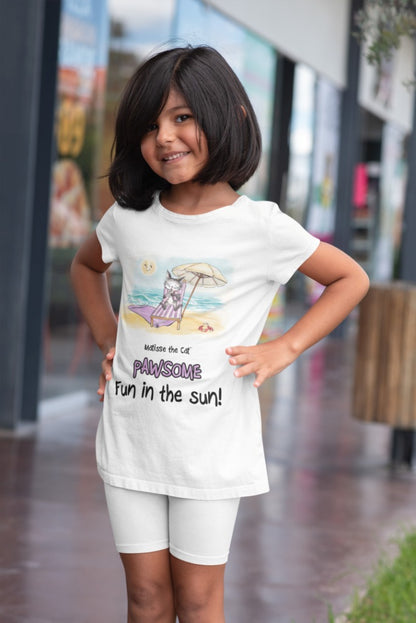 A white official, Matisse the Cat children’s t-shirt with the slogan ‘Pawsome Fun in the Sun ‘ showcases Matisse at the beach, relaxing on a sun lounger sipping a mile shake. Worn by a young girl standing outside a shop.